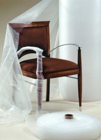 a bubble wrap roll next to a chair demonstrating that it can be used to protect the material