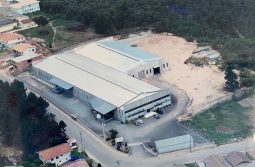 aerial image of 5 estrelas papeis e embalagens in the 2000s, contains 2 sheds in gray and blue color plus parking for cars.